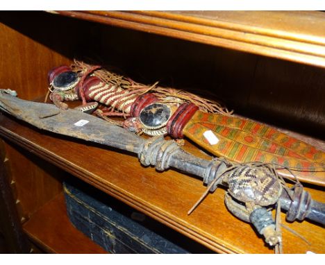 A tribal machete in tooled leather scabbard and 2 others.