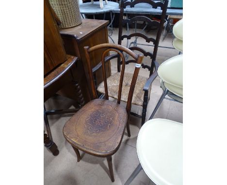 A Thonet Bentwood dining chair with carved seat and an oak ladder back rush seated elbow chair.