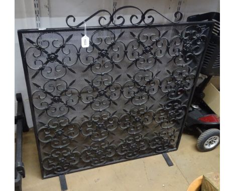 A scrolled wrought-iron and mesh firescreen, width 2'7".