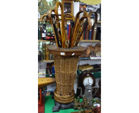 Walking sticks in a basket weave stick stand.