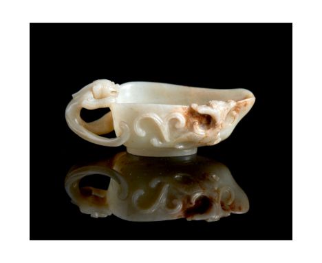 A pale celadon and russet flecked jade pouring vesselQing dynasty, 18th centuryWith a large chilong forming the handle and a 