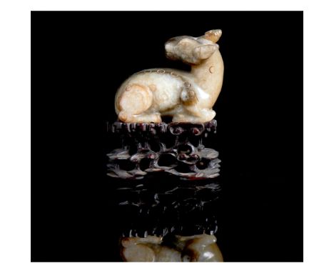 A carved jade figure of a recumbent deerQing dynasty, 19th / 20th centuryWith carved wooden standProvenance:Property of  Port
