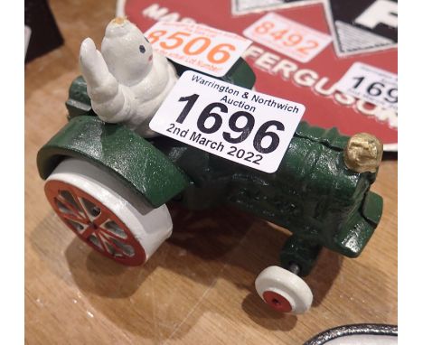 Cast iron Michelin Man on a tractor, 10 x 8 cm. P&amp;P Group 1 (£14+VAT for the first lot and £1+VAT for subsequent lots) 