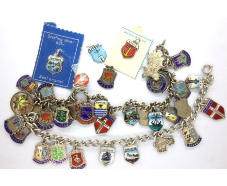 Two silver and enamel badges and a sterling charm bracelet, combined 60g. P&amp;P Group 1 (£14+VAT for the first lot and £1+V