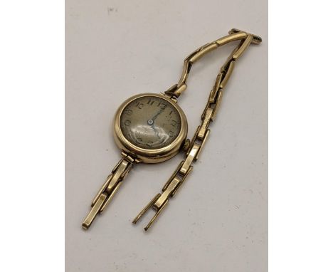An early 20th century 9ct gold ladies manual wind watch on a gold plated expanding bracelet, Location: 