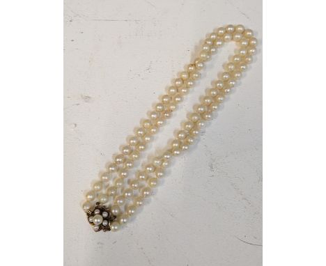 A double string pearl necklace with a gold clasp, stamped 14kLocation: 