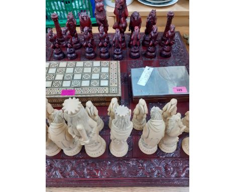 An Alice in Wonderland style composition chess set, together with a playing card storage box, a small pocket chess set and a 