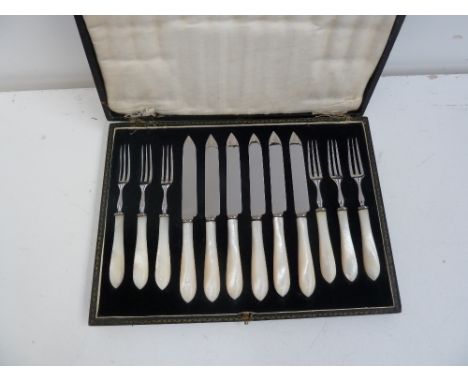 A set of six 20th century stainless steel and mother of pearl handle knife and forks, by W.H&S., in their box