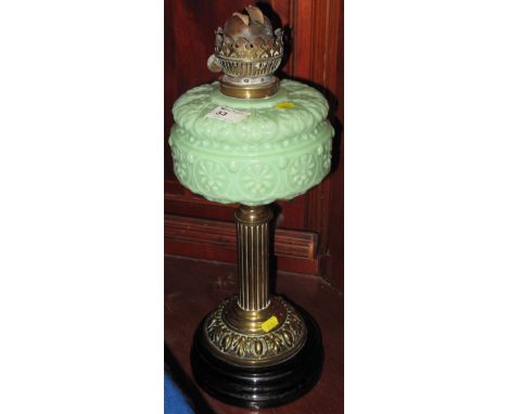 Early 20th Century brass double burner oil lamp with moulded pale green glass reservoir and brass pedestal on ceramic base.  