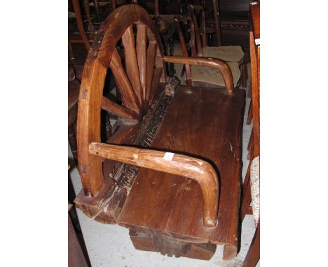 Large rustic open arm bench with wagon wheel back.