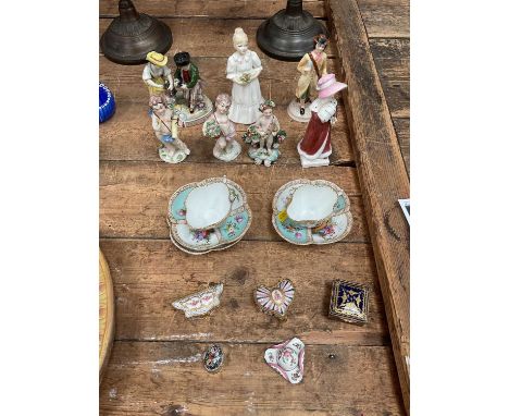 Group of ceramics, including continental figures, Dresden cups and saucers, trinket boxes, and a miniature antique enamel hat