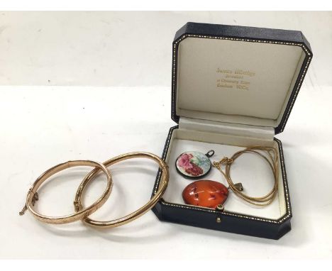 Two gold hinged bangles, one 9ct and one 14ct, silver and enamel locket and an amber pendant on plated chainOne bangle with e