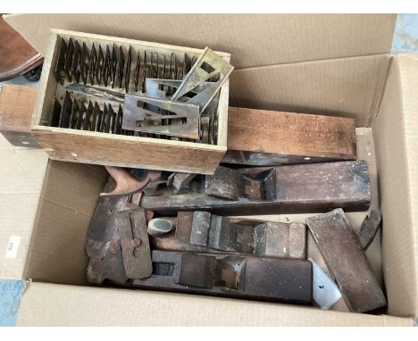 Box of vintage woodworking tools including planes and a boxed scientific instrument