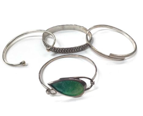 Silver bangle with green enamelled leaf decoration together with other three silver/white metal bangles (4)