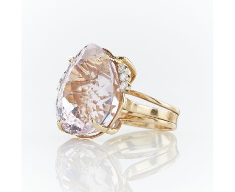 14k yellow gold cocktail ring set with large pear cut kunzite and three brilliant cut diamonds on either side of the central 