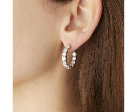 14k white gold diamond hoop earrings. Each set with 11 round brilliant cut diamonds, seven on the front of the hoop and 4 on 