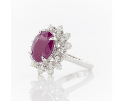 14k white gold ring set with an oval cut 4.03 carat ruby. Surrounded by a halo of 24 brilliant cut diamonds of 0.48 carat tot