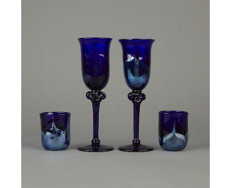 Group of four Roland R. Correia studio art glass vessels including two wine glasses with tall stems and two cups. Cobalt blue