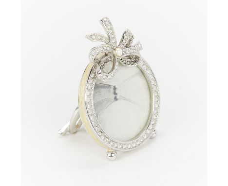 Jay Strongwater, United States. Small round frame with a border of Swarovski crystals. Topped with a bejeweled bow. The edges