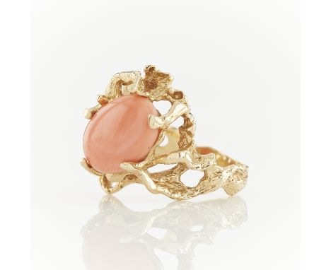 14k yellow gold ring of naturalistic form set with an oval coral cabochon. Marked along the interior shank B 14k in a rectang
