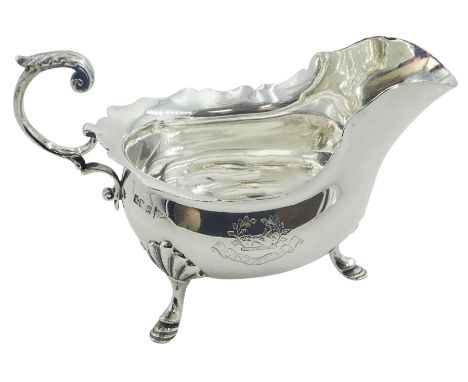 Edwardian silver sauce boat, with shaped rim and acanthus capped flying scroll handle, the body engraved with boar's head cre