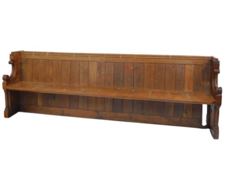 A 19thC oak church pew, with a panelled back, solid seat, scrolling arms, raised on cylindrical columns, on a block base, 90c
