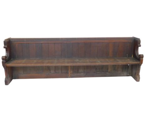 A 19thC oak church pew, with a panelled back, solid seat, scrolling arms, raised on cylindrical columns, on a block base, 90c