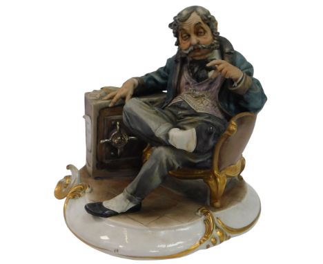 A Capodimonte porcelain figure, modelled as a seated gentleman smoking a cigar, beside a safe, 22.5cm high. 