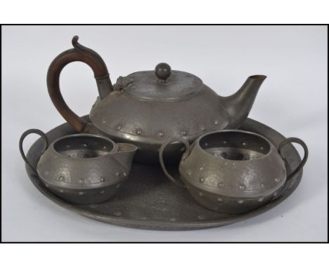 An Arts & Crafts pewter 4 piece tea service comprising teapot, sugar bowl, creamer and tray. Stamped for Homeland W&C L27cm