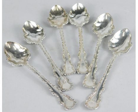 A set of six late Victorian silver coffee spoons, each with an elaborate scroll cast handle and part of the bowl, with taperi