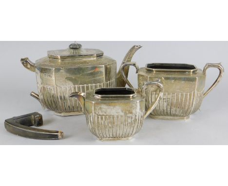 A late Victorian silver associated three piece tea set, of canted rectangular form, with part fluted decoration, various date