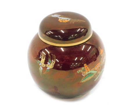 A Carltonware ginger jar and cover, on a red ground with buildings and pagodas, and a gilded border, 10cm high.