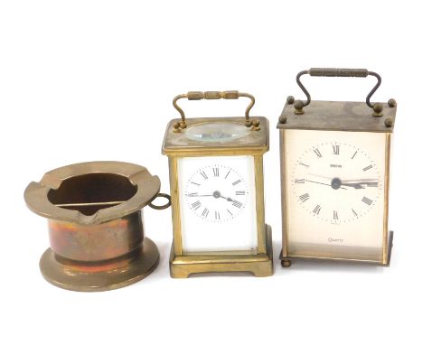 A 20thC brass carriage clock, glass panelled interior on a white enamel face, with Roman numerals, with swing handle, stamped