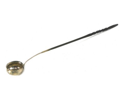 A 19thC toddy ladle, with twist ebonised handle, on a white metal hammered floral and grape vine bowl, unmarked, 39cm long. 
