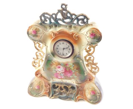An early 20thC pottery clock case, printed with flowers, etc., mounted with a foreign movement, 46cm high. 