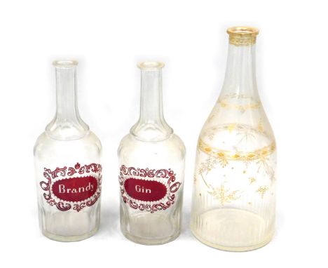 A pair of 19thC bottle shaped cut glass decanters, one with ruby flash decoration brandy, the other gin, 25.5cm high, and ano