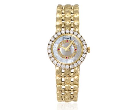 Piaget. A recently serviced lady's 18K gold diamond and ruby set quartz bracelet watch with mother of pearl dialReference: 82