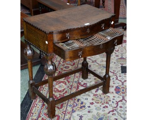An early 20th century oak canteen on stand, a pair of drawers containing cutlery