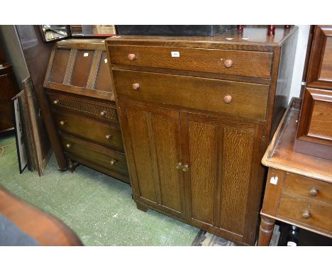 An oak tallboy, two long drawers over two door cupboard; an oak bureau, panelled fall front, three drawers to base. (2)
