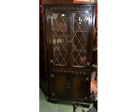 An oak floor standing corner cupboard with glazed leaded light