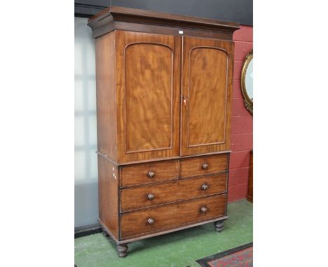 A George III mahogany linen press, outswept cornice, two arched panel doors enclosing five slides to top, two short cockbeade
