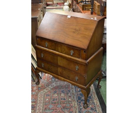 A walnut bureau, fall front over single drawer to top, stepped base, two long drawers, shaped apron, cabriole supports, ball 