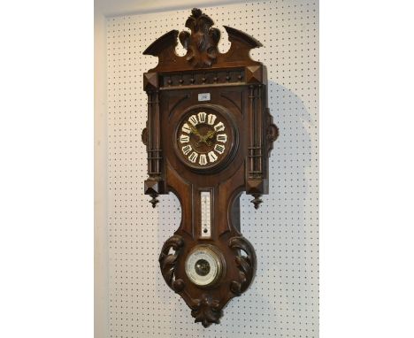 A carved French oak clock/weather station, armorial pediment, Roman numerals on enamelled shield shaped escutcheons, flanked 