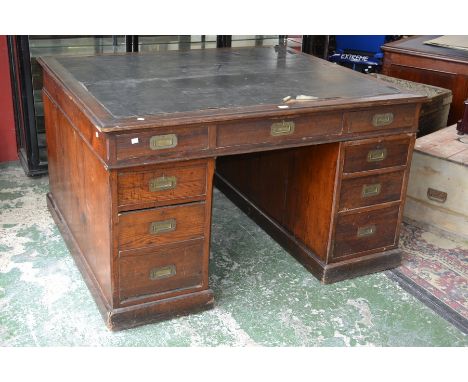 A stained pine partners desk, leather inlaid top, five drawers to frieze, brass campaign handles.