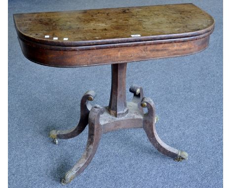 A Regency mahogany card table, foldover top enclosing red baize playing area, incurved octagonal column, quatrefoil socle, sc