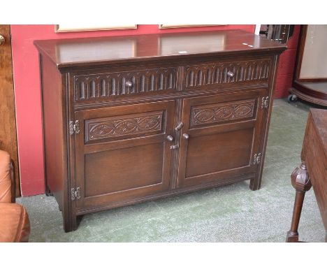 An oak Jaycee sideboard, rectangular oversailing top, two fluted short drawers over carved panel two door cupboard, acorn han