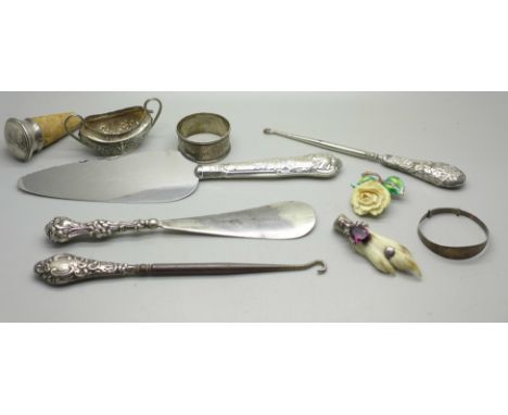 A collection of silver and silver mounted items including silver handled implements, silver bangle, napkin ring, enamelled br