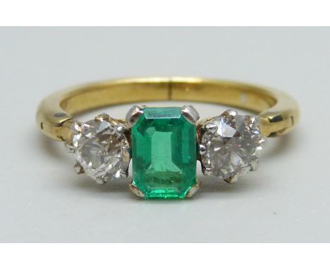 A yellow metal ring set with a central emerald and two diamonds, 3.8g, Q/R, emerald 5mm x 7mm, shank opens/expands 