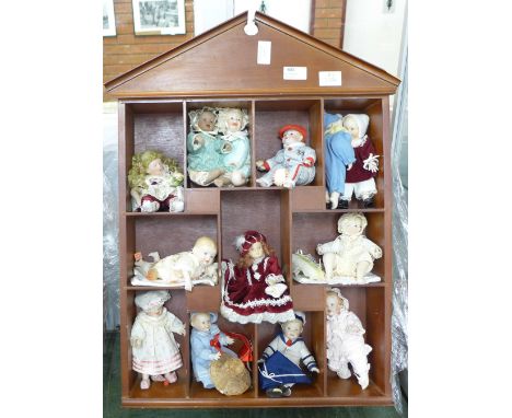 A doll display case with thirteen small china dolls and one other larger doll **PLEASE NOTE THIS LOT IS NOT ELIGIBLE FOR POST