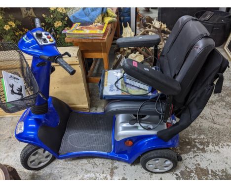 A Kymco Force Super 8 mobility scooter with wirework shopping basket to front, battery charger and storage cover, rucksack to